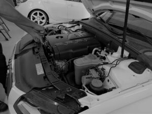 Mechaniker arbeitet im Motorraum eines Autos